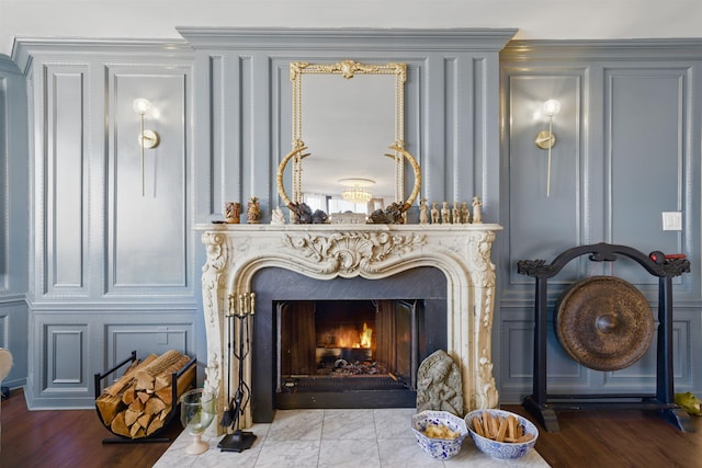 room details with a premium fireplace, wood finished floors, and a decorative wall