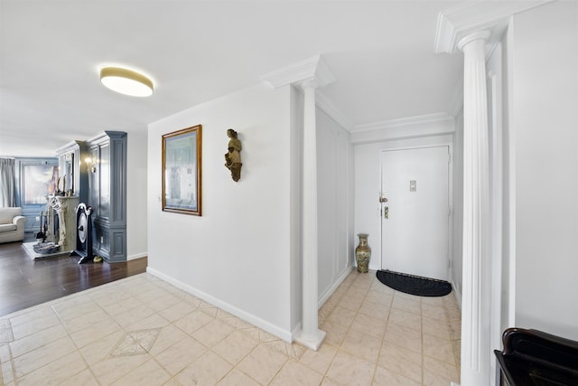 foyer entrance featuring decorative columns, ornamental molding, and light tile patterned flooring