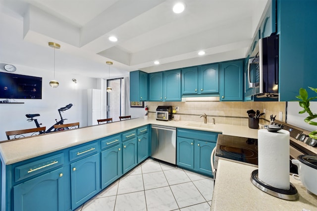 kitchen with recessed lighting, stainless steel appliances, a peninsula, a sink, and tasteful backsplash