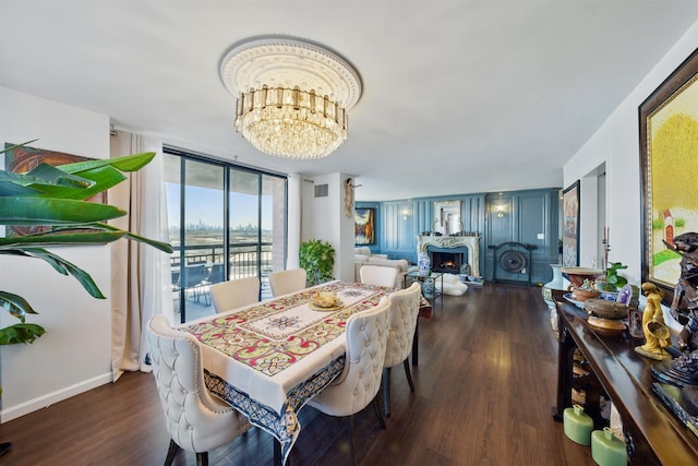 dining area with a warm lit fireplace, visible vents, wood finished floors, an inviting chandelier, and expansive windows