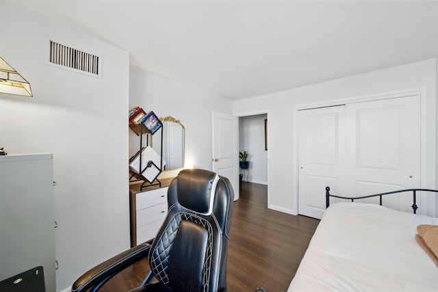 bedroom featuring dark wood-type flooring, a closet, visible vents, and baseboards