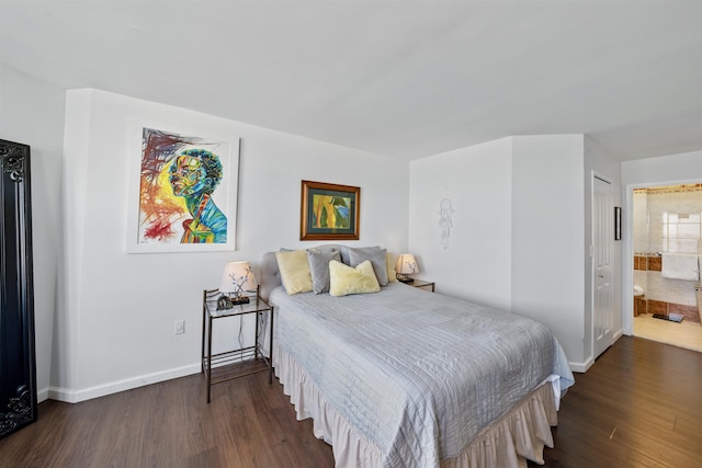 bedroom with dark wood-style flooring, baseboards, and ensuite bathroom