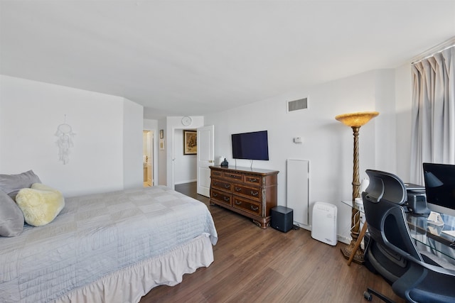 bedroom featuring baseboards, visible vents, and wood finished floors