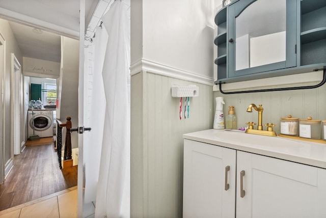 26 E 49th St, Bayonne, NJ 07002 - full bathroom featuring washer / clothes dryer, vanity, wainscoting, a decorative wall, and wood finished floors
