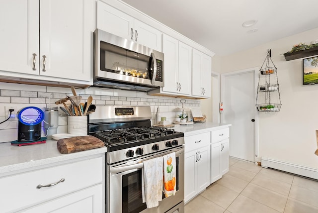 26 E 49th St, Bayonne, NJ 07002 - kitchen with stainless steel appliances, backsplash, a baseboard heating unit, light countertops, and light tile patterned floors
