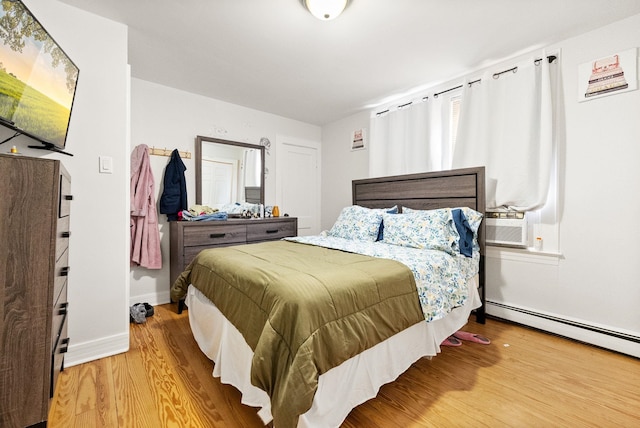 26 E 49th St, Bayonne, NJ 07002 - bedroom with wood finished floors, baseboards, a baseboard heating unit, and cooling unit