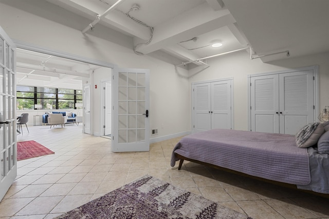300 Communipaw Ave Unit 17, Jersey City, NJ 07304 - bedroom with french doors, light tile patterned floors, multiple closets, and track lighting