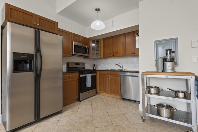 300 Communipaw Ave Unit 17, Jersey City, NJ 07304 - kitchen with stainless steel appliances, dark countertops, a sink, glass insert cabinets, and brown cabinetry