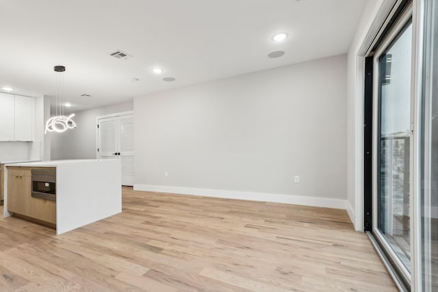 27 E 16th St Unit 2, Bayonne, NJ 07002 - kitchen featuring light wood finished floors, light countertops, decorative light fixtures, white cabinetry, and recessed lighting