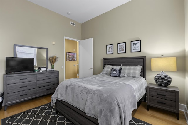 bedroom featuring visible vents and wood finished floors