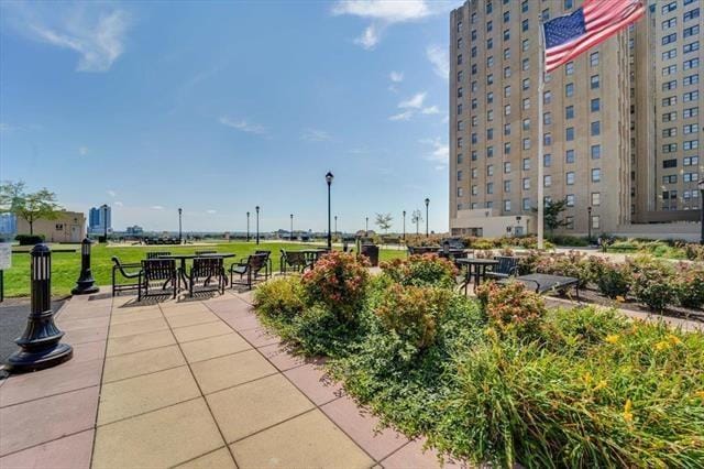 view of home's community featuring a patio area, a yard, and outdoor dining space