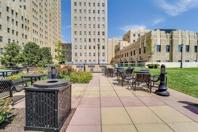 surrounding community featuring a view of city, a patio area, and a yard