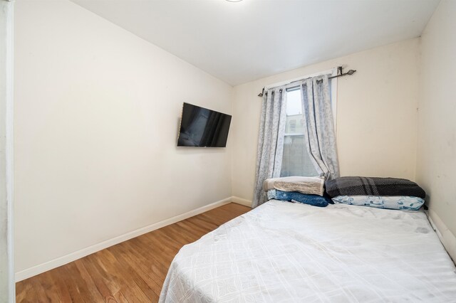 bedroom featuring wood-type flooring and vaulted ceiling