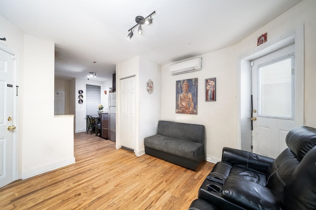 living room featuring light wood-type flooring and a wall mounted air conditioner