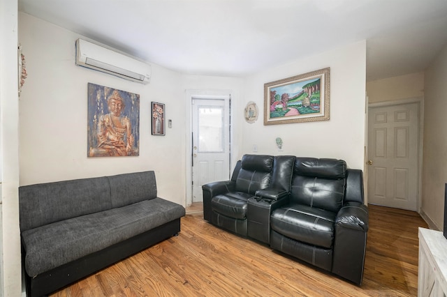 living room featuring an AC wall unit and light hardwood / wood-style floors