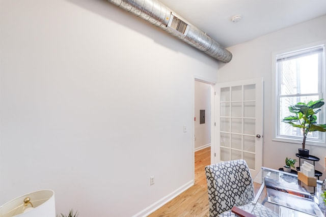 home office featuring electric panel and light hardwood / wood-style flooring