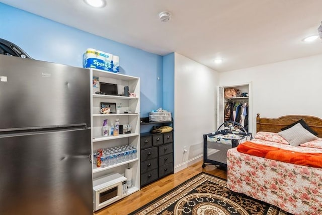 527 Kennedy Blvd, Bayonne, NJ 07002 - bedroom with recessed lighting, baseboards, freestanding refrigerator, and wood finished floors