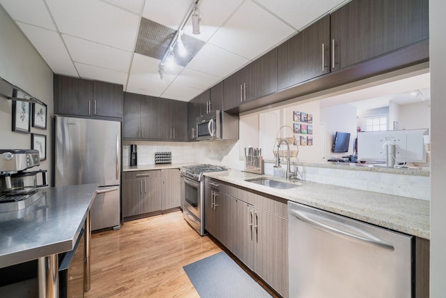 186 Wayne St Unit D-106, Jersey City, NJ 07302 - kitchen featuring appliances with stainless steel finishes, a sink, light wood-style flooring, dark brown cabinetry, and backsplash