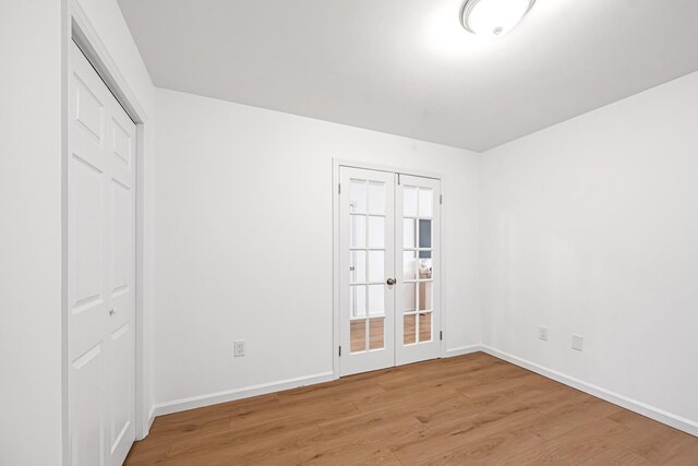 127 Jane St, Weehawken, NJ 07086 - unfurnished bedroom with french doors, light wood finished floors, and baseboards