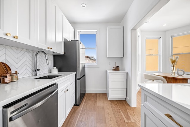 127 Jane St, Weehawken, NJ 07086 - kitchen featuring appliances with stainless steel finishes, a sink, light countertops, backsplash, and white cabinets