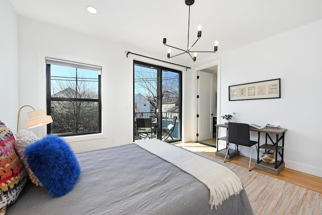 77 Clerk St Unit 1, Jersey City, NJ 07305 - bedroom featuring wood finished floors, access to outside, a chandelier, and baseboards