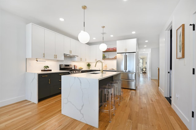 77 Clerk St Unit 1, Jersey City, NJ 07305 - kitchen featuring appliances with stainless steel finishes, a sink, a breakfast bar, light wood finished floors, and baseboards