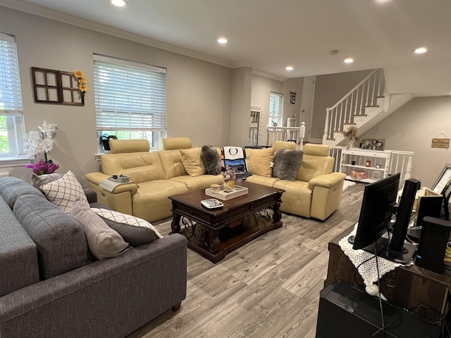 living room with crown molding and light hardwood / wood-style flooring