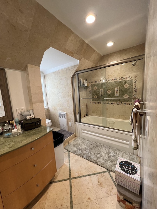 full bathroom featuring toilet, tile patterned flooring, tile walls, enclosed tub / shower combo, and vanity