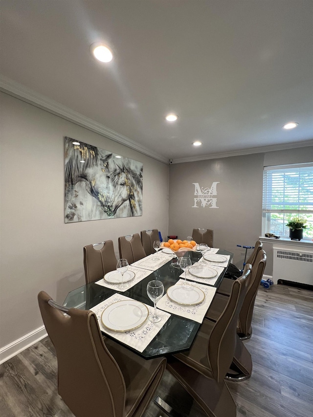 dining space featuring dark hardwood / wood-style flooring, crown molding, and radiator heating unit