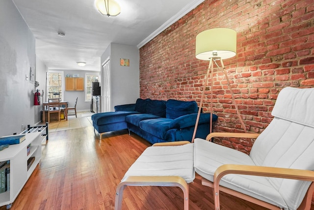 living room featuring brick wall and light hardwood / wood-style flooring