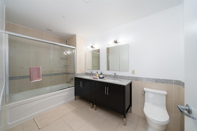 1 Shore Ln Unit 1208, Jersey City, NJ 07310 - full bath featuring tile patterned flooring, enclosed tub / shower combo, double vanity, tile walls, and a wainscoted wall