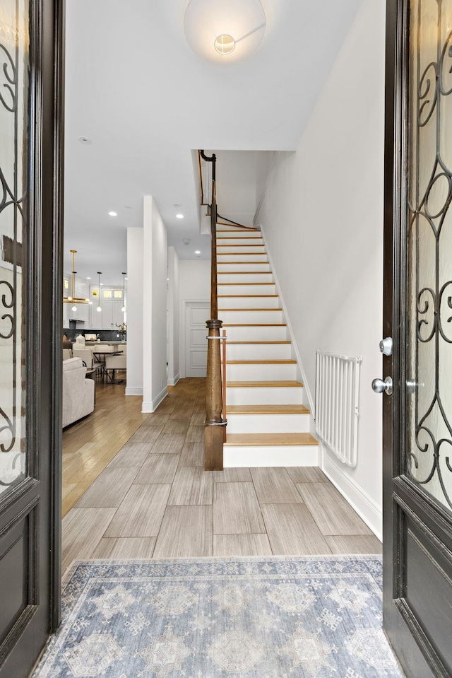 foyer entrance featuring recessed lighting, stairs, baseboards, and wood tiled floor