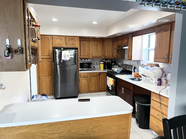 304 51st St, West New York, NJ 07093 - kitchen with freestanding refrigerator, range with gas stovetop, under cabinet range hood, stainless steel microwave, and light tile patterned floors