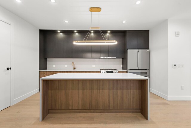 kitchen featuring sink, pendant lighting, a center island, and high end fridge