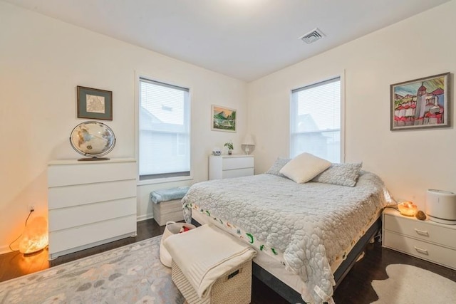 bedroom featuring multiple windows and dark hardwood / wood-style floors