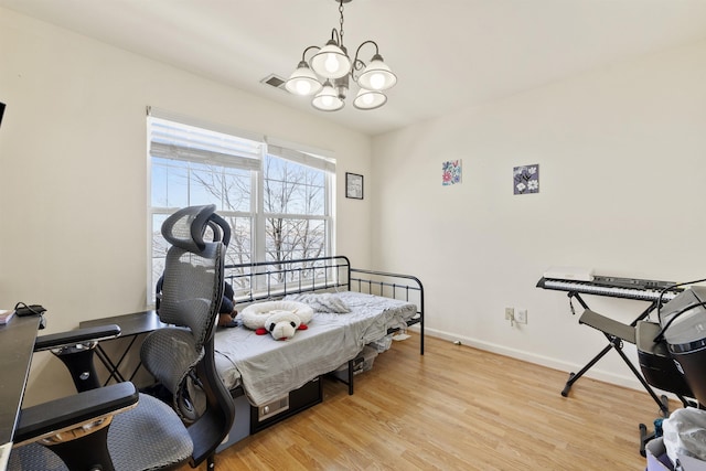 bedroom with a chandelier and light wood-type flooring