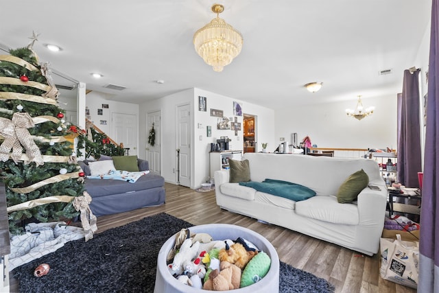 living room featuring wood-type flooring and an inviting chandelier