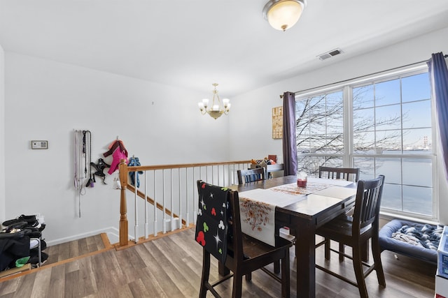 dining space featuring a notable chandelier and wood-type flooring