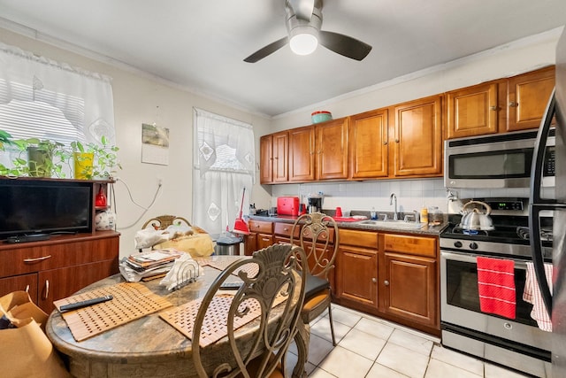 kitchen with decorative backsplash, stainless steel appliances, crown molding, sink, and light tile patterned flooring