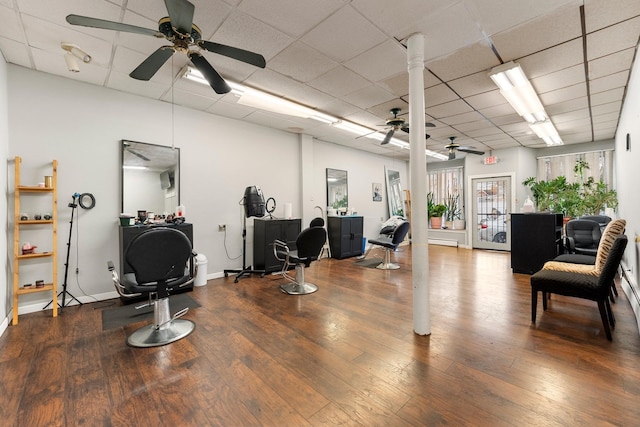 exercise room with hardwood / wood-style floors, a drop ceiling, and ceiling fan