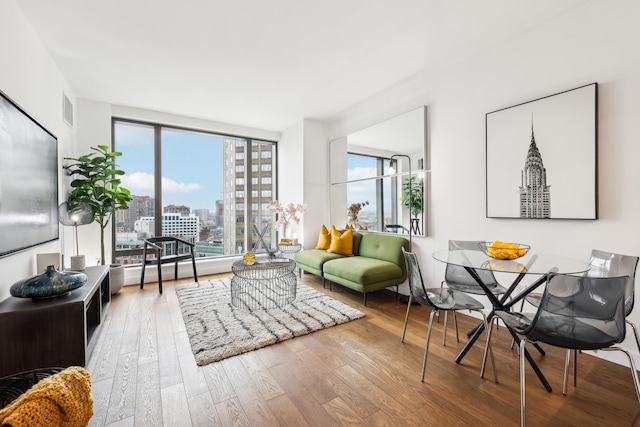 living room featuring expansive windows, a healthy amount of sunlight, and hardwood / wood-style flooring