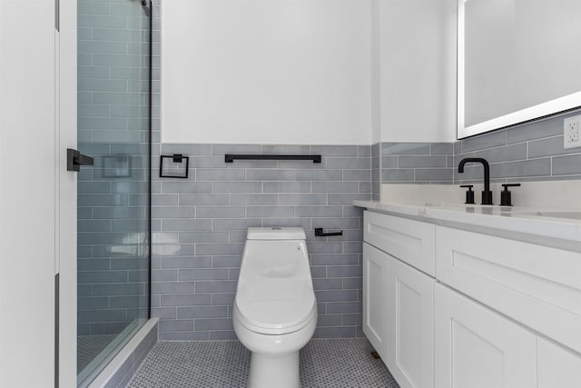 bathroom featuring tile patterned flooring, vanity, tiled shower, and toilet