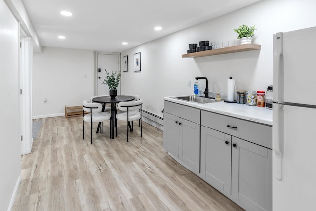 kitchen with recessed lighting, a sink, light wood-type flooring, freestanding refrigerator, and open shelves