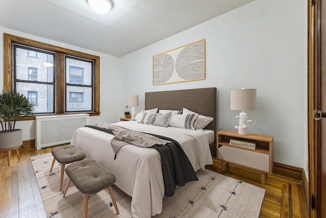 bedroom with wood-type flooring and radiator