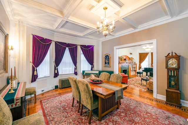 dining space featuring an inviting chandelier, parquet flooring, radiator heating unit, and coffered ceiling