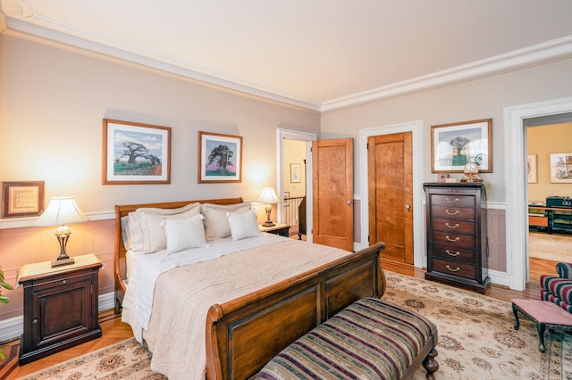 bedroom with ornamental molding and light hardwood / wood-style flooring