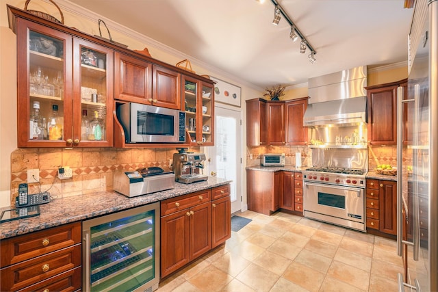 kitchen with wine cooler, crown molding, appliances with stainless steel finishes, light stone countertops, and wall chimney range hood