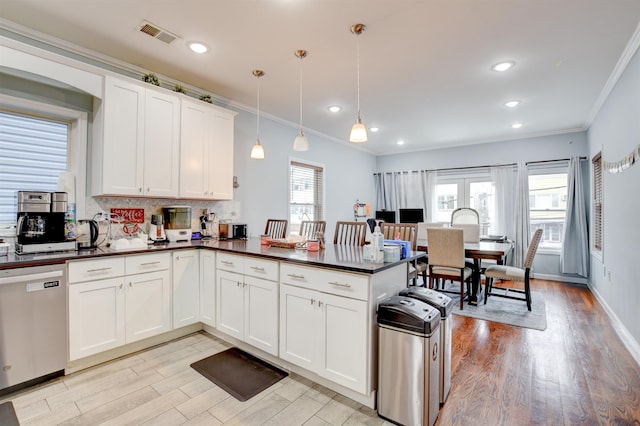kitchen featuring crown molding, light wood-type flooring, stainless steel dishwasher, dark countertops, and visible vents