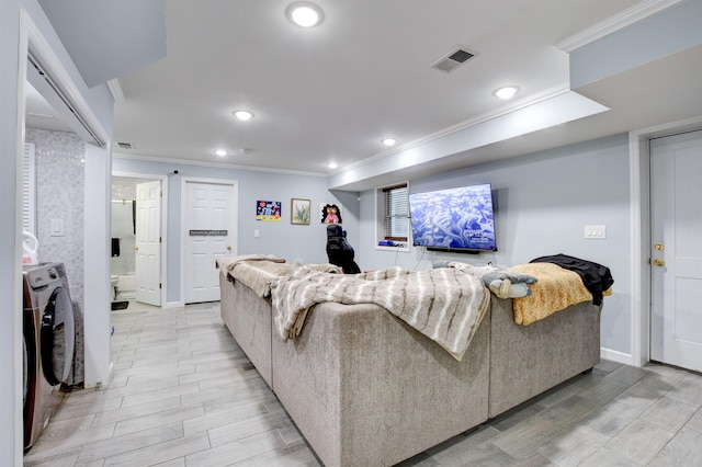 living area featuring washer / dryer, visible vents, wood finish floors, and crown molding