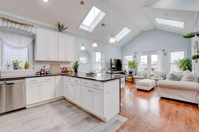 kitchen featuring stainless steel dishwasher, open floor plan, dark countertops, and a skylight